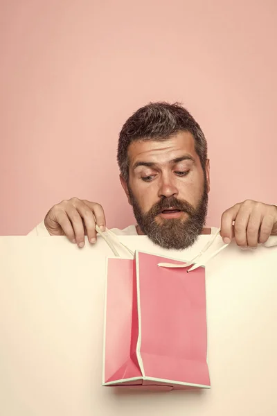 Man met verbaasd gezicht en cadeaupakket. — Stockfoto