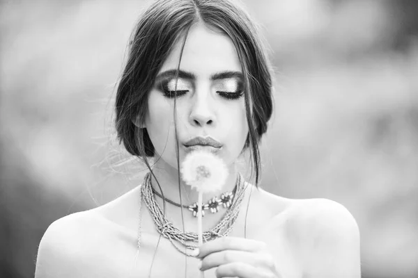 Woman with fashionable makeup blowing dandelion, hairloss — Stock Photo, Image