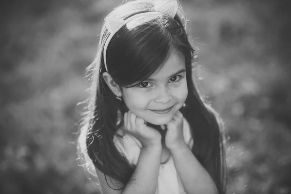 Menina pequena com sorriso adorável na grama verde, beleza — Fotografia de Stock