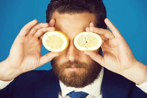 lemon at face of man with beard or businessman