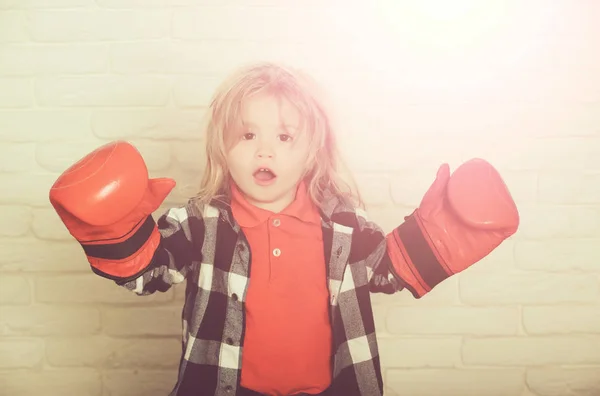 Heureux petit garçon en gants de boxe rouge, pose gagnante — Photo