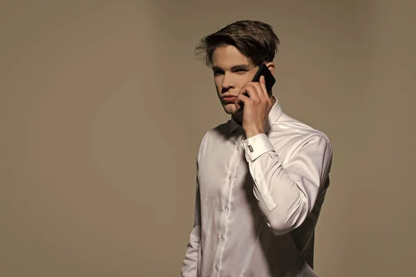 Uomo parlare sul telefono cellulare su sfondo grigio — Foto Stock