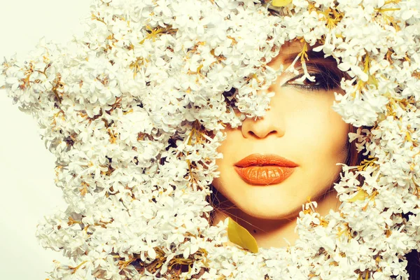 Modelo de menina bonita em flores lilás em torno do rosto com lábios sexy no fundo branco . — Fotografia de Stock