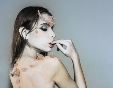 Dikenler geri omuzlarında kadınla fantezi yaratık gibi görünüyor. Korkunç Peri kuyruk karakter. Cadılar Bayramı fikirler kavramı. Dikenler şeytan ejderha büyülü yaratık olan kız. Fantezi tarzı ile kız makyaj