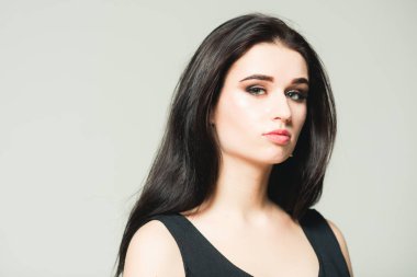 Gri arka plan üzerinde izole oldukça esmer kadın. Uzun siyah saçlı Genç modeli portresi