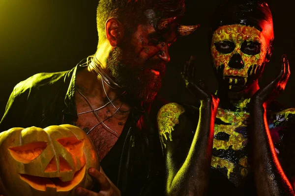 Pareja de Halloween con calabaza de hombre demonio y cráneo de niña —  Fotos de Stock