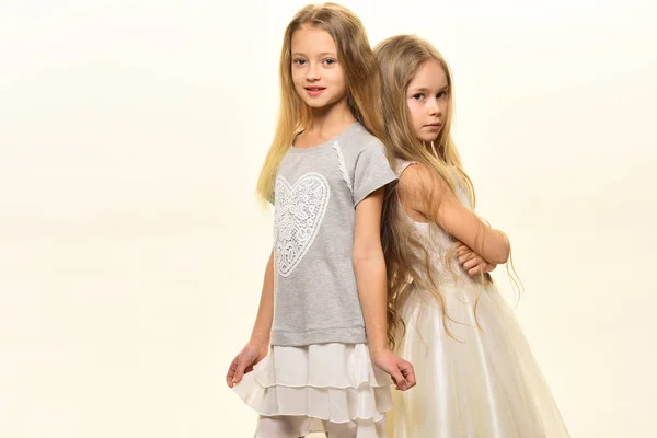 Αδελφές. δύο κορίτσια αδελφές απομονωμένα σε λευκό. Μόδα αδελφές με μακριά μαλλιά. μικρές αδελφές ποζάρει μαζί, αντίγραφο χώρου. — Φωτογραφία Αρχείου
