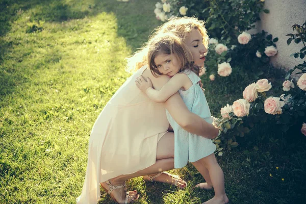 Mamma pussar dotter på grönt gräs på solig sommardag — Stockfoto