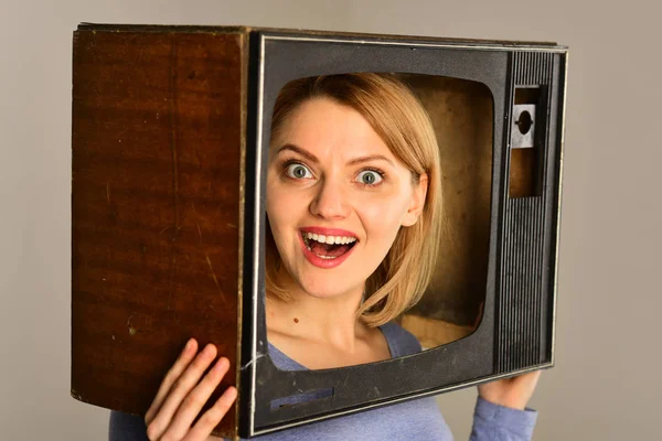 TV. vrouw op zoek via het tv-toestel. vrouw houd tv-toestel op hoofd. goed nieuws op tv. gelukkig gevoel — Stockfoto