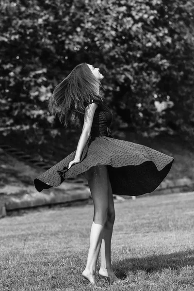 Atrakcyjna, młoda dziewczyna w granatowa sukienka na trawniku — Zdjęcie stockowe
