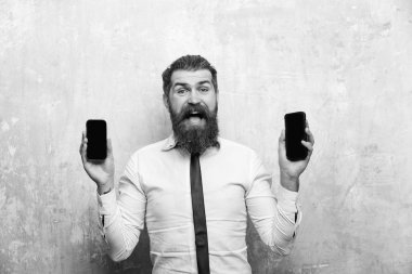 sakallı adam veya hipster karşılaştırmak hareket eden telefon ve smartphone