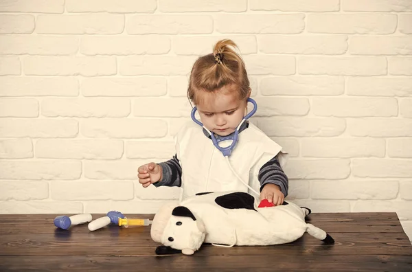Детский ветеринар осматривает игрушечное животное стетоскопом — стоковое фото