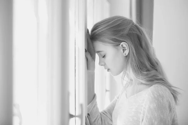 Hübsches Mädchen steht am Fenster — Stockfoto