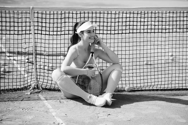 Žena na tenisový kurt s míče a rakety — Stock fotografie
