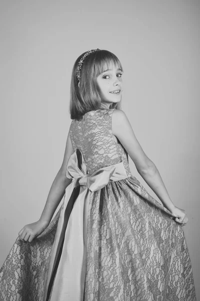 Cabeleireiro, maquilhagem. Menina criança em vestido de glamour elegante, elegância. Menina em vestido elegante, baile de finalistas. Modelo de moda em fundo rosa, beleza. Moda e beleza, pequena princesa — Fotografia de Stock