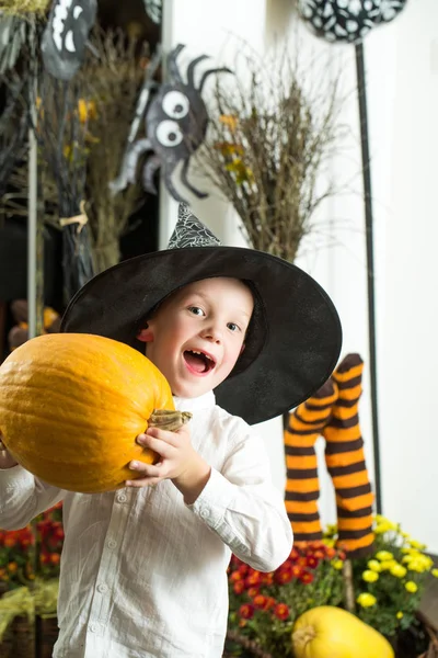 Halloween niño con calabaza naranja en sombrero de bruja . —  Fotos de Stock