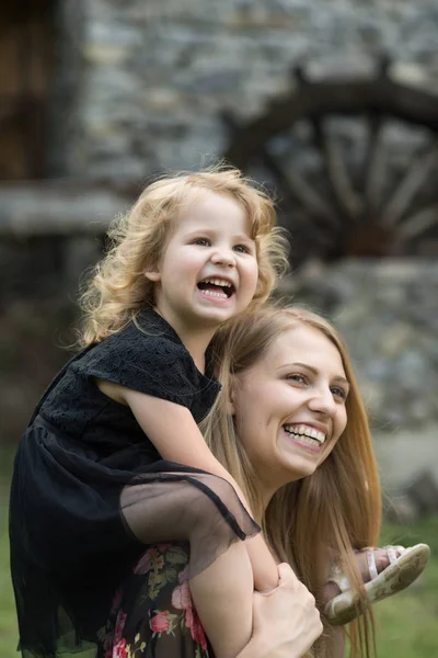 Fille enfant sourire sur femme épaules — Photo