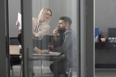 Başarı için işbirliği. İş kadını ve işadamı iş planı yazmak. İş üzerinde yoğunlaşmıştır. Şehvetli kadın ve sakallı adam birlikte ofisinde çalışıyorum. Yoğun bir gün ofiste