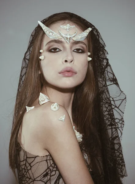 Mystic fairy tail character. Woman with horns and thorns wears black veil fantasy creature. Girl with fantasy style make up. Halloween ideas concept. Girl with thorns as devil dragon magical creature