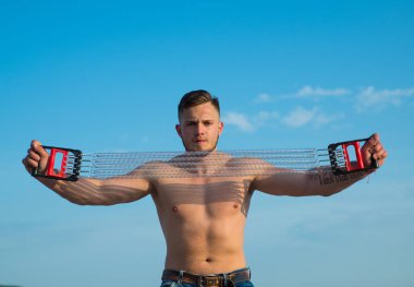 Sağlıklı bir yaşam tarzı. Sağlıklı sporcu mavi gökyüzü eğitim. Sağlıklı bir insan direniş band germek. Temiz hava üzerinde sağlıklı egzersiz. Kendini zorla