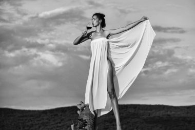 Gökyüzünde şarap şişesi olan güzel kız.