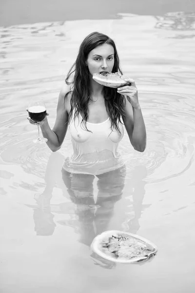 sexy girl with watermelon and wine in pool