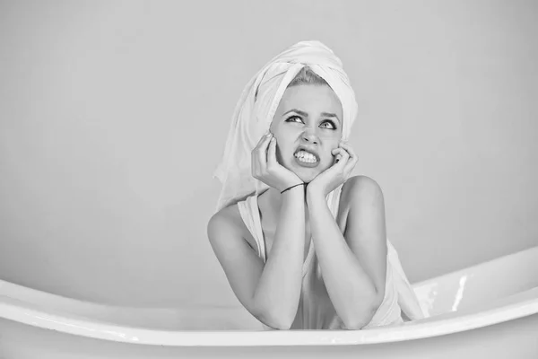 Mulher com turbante de toalha sentado na banheira branca — Fotografia de Stock