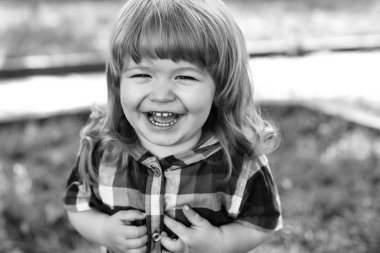 Yeşil çimenlerin üzerinde mutlu küçük çocuk