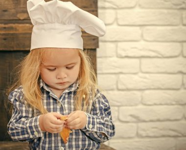 Çocuk chef şapka ve un yüz ve mutfakta oynarken gömlek