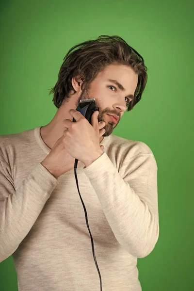 Man trimmen baard haar met elektrisch scheerapparaat. — Stockfoto