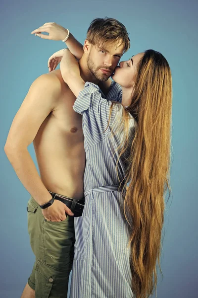 Женщина целует мужчину на синем фоне — стоковое фото