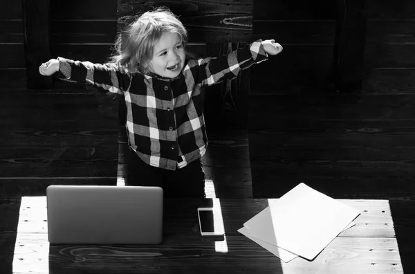 Niño feliz en la oficina con el ordenador portátil, teléfono, hoja de papel —  Fotos de Stock