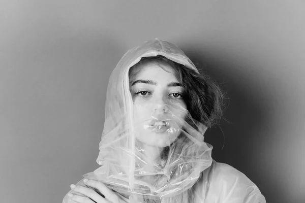 fashion woman with polyethylene or plastic raincoat and bag