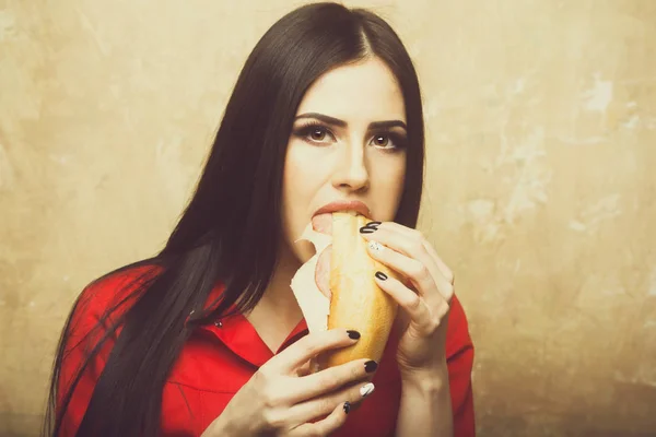 Sexy pretty brunette woman eats big sandwich or burger — Stock Photo, Image