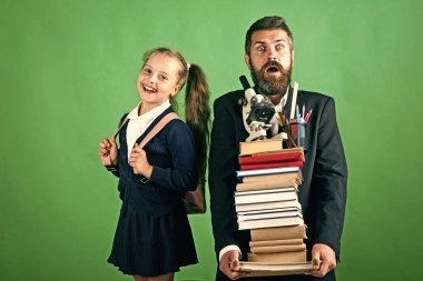 Ev okul ve okul kavramı dön. Baba ve yeşil renkli sürpriz ve gülümseyen yüzleri ile kız öğrenci. Çocuk ve baba kitap yığını ve ileti örneği tutun. Kız ve takım elbiseli sakallı adam