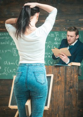 Bir at kuyruğu bacaklarının arasında bir kitap tutarken yapma kız geri dön. Genç öğrenci dikiz. Profesör arka planda bulanık kitap okuma