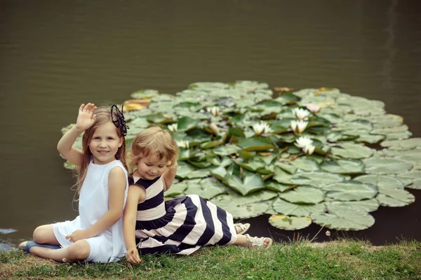 Дівчина хвиля рука в ставку з квітами з водяної лілії — стокове фото