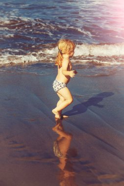 Islak kum deniz boyunca şirin neşeli bebek çocuk ishal