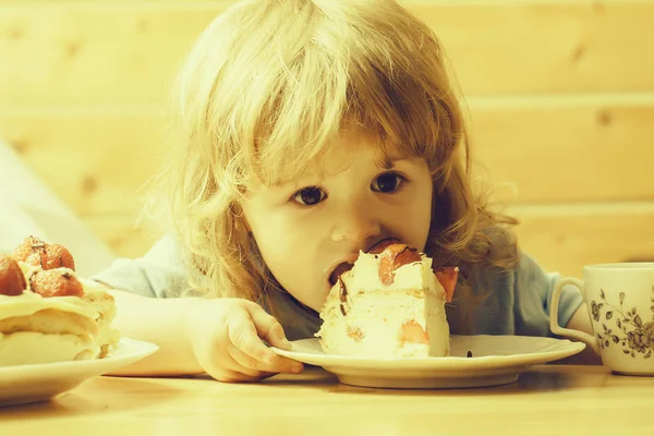 Malý chlapec jí jahodový dort — Stock fotografie