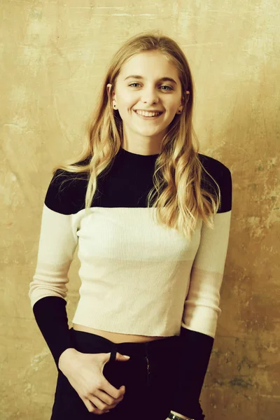 Красива щаслива дівчина в штанях і сорочці на фоні стіни — стокове фото