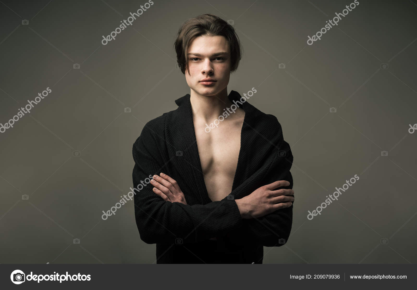 Guy Sur Un Visage Confiant En Peignoir Noir Détient Bras