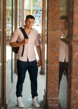 Seyahat çantası güneşli üzerinde olan adam açık. Maço moda gömlek ve pantolon moda. Sokak moda modeli. Sırt çantası tatilde yakışıklı adam. Gençlik stil kavramı