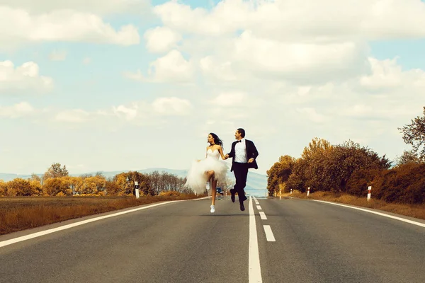 Małżeństwo, które biegną wzdłuż drogi — Zdjęcie stockowe