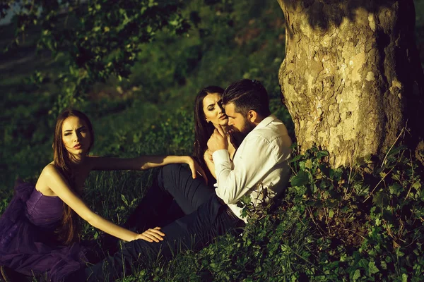 Bärtiger Mann und zwei Frauen im Gras — Stockfoto