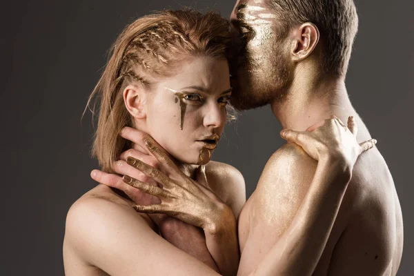 Wurgen concept. wurgen van meisje door man, beide hebben gouden verf op lichaam. — Stockfoto