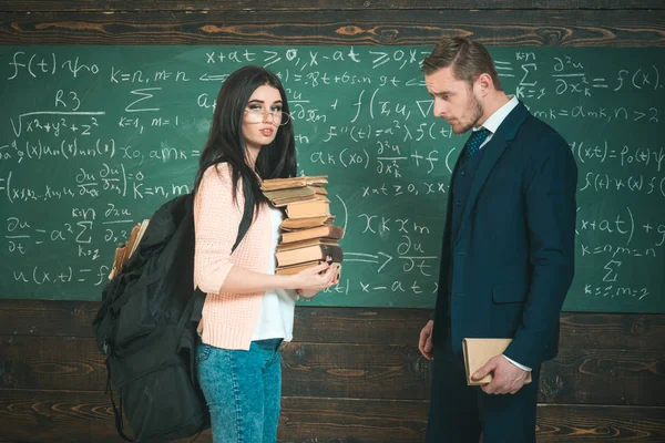 La literatura me interesa. Estudiante en gafas con pila de libros y soporte de mochila con profesor en pizarra en el aula. Más conocimiento. Gusano de biblioteca. Me encanta leer. — Foto de Stock