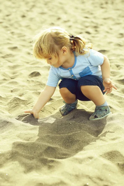 Söt baby boy spela med sand — Stockfoto