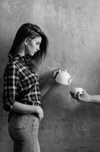 Menina bonita derramando chá para xícara na mão masculina — Fotografia de Stock