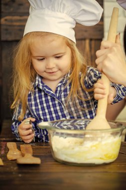 Tahta kaşıkla hamur karıştırma Şef şapkalı çocuk çocuk