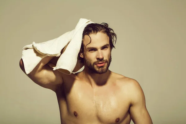 Hombre con musculoso húmedo cuerpo mantenga la toalla en baño —  Fotos de Stock